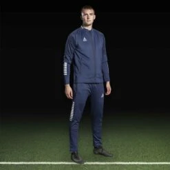 SELECT Monaco Training Pants Slim Fit -Sports Wear Shop 12256008 610118 navy white 610112 navy white Zip jacket pants Slim Fit Monaco v24 football model2 028c8779 2253 4f73 9f7c 47fc6ff086aa